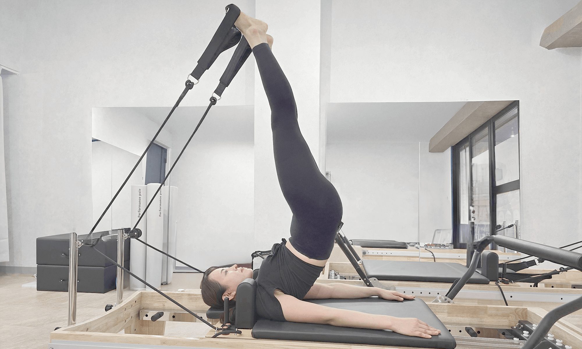 女性がトレーニング台の上に寝ながらストレッチをしている画像