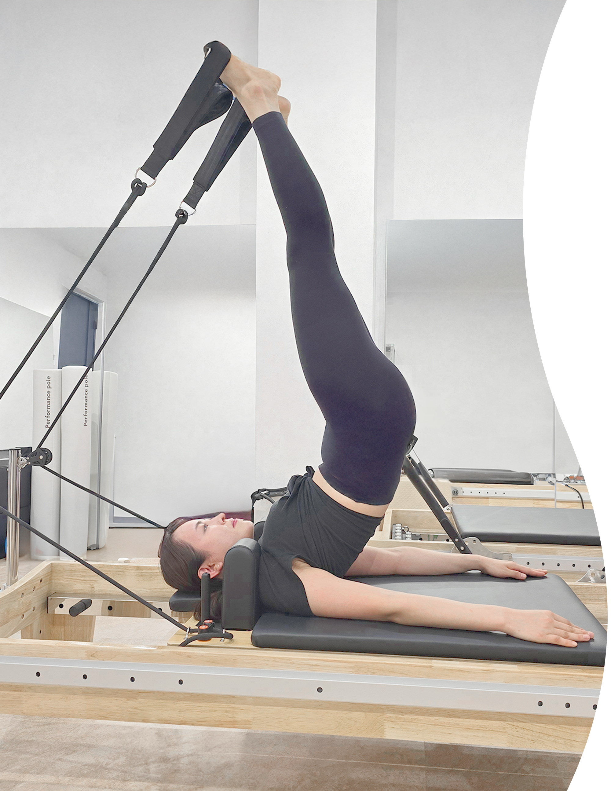 女性がトレーニング台の上に寝ながらストレッチをしている画像